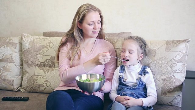 woman with her daughter eat salad