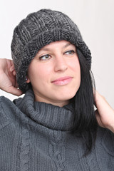 happy woman listening to music with headphones and wearing winter clothes and hat