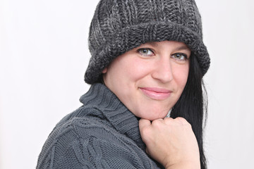 happy woman listening to music with headphones and wearing winter clothes and hat