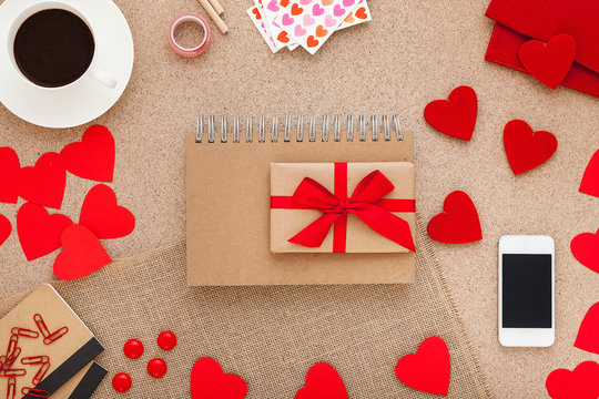 Preparing for a date on Valentine's Day,gift, scrapbook and smartphone on a girlish desk.