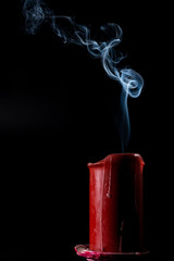 smoke goes up from the extinct red candle