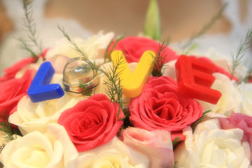 gelin buketi beyaz ve kırmızı güller gelin yüzüğü, güllerin üstünde düğün yüzükleri aşk yazısı ve genç kadın kutlama evlilik ve nikah töreni ve gelin