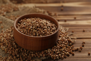 Buckwheat seeds in bowl on a brown wooden table