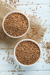Buckwheat seeds in bowl on a blue wooden table