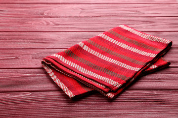 Napkin on red wooden table, close up