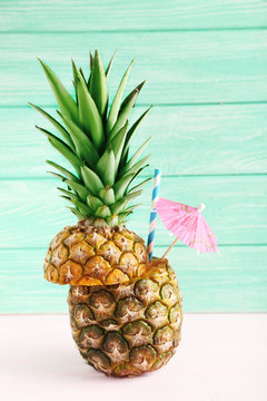 Ripe pineapples on a pink wooden background