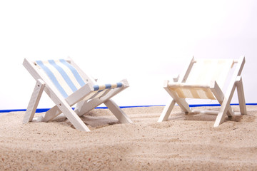 zwei leere Liegestühle am Strand