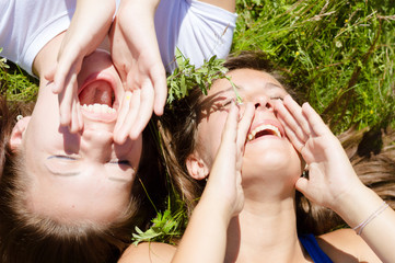 two beautiful girls lying on hay one summer day outdoors