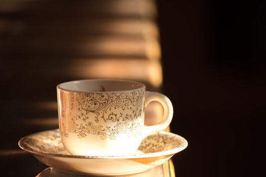 Una taza con su plato de porcelana sobre la mesa.