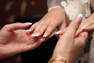 Obraz na płótnie Canvas bridesmaid looks at the manicure of the bride