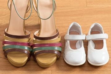 Heeled shoes of mom with daughter's ballerinas