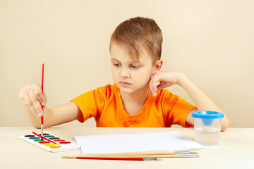 Beginner artist in an orange shirt going to paint watercolors