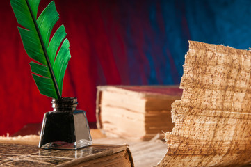 Green quill pen and a backlit papyrus sheet