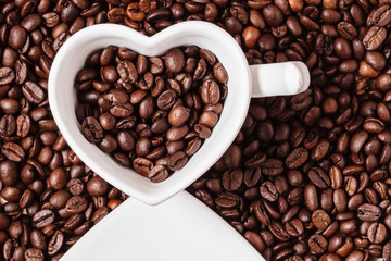 White cup on coffee beans background