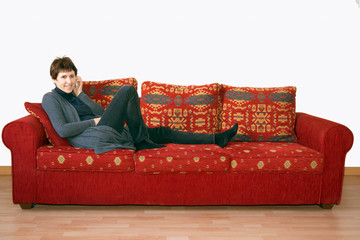 Obraz premium Older, mature woman gossiping on mobile phone on sofa.
