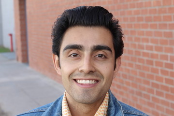 Obraz premium Close up portrait of Arabic nice man on the background of red brick wall. 