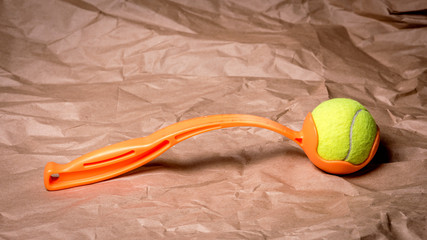 Tennis ball launcher with an orange handle