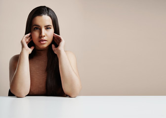 plus size woman touching her face