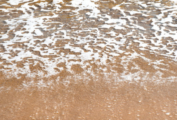 Fototapeta na wymiar Surf. Close-up of a sea foam and sandy coast