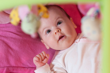 Happy baby playing on his bed