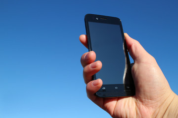 black smart phone and the hand in the blue sky #2