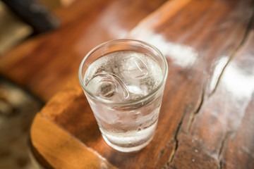 Glass with ice cubes on wooden table - Glass of very cold water ( top view )
