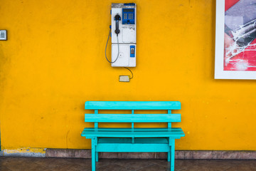 Antique wooden chair blue with cell wall with a yellow background.