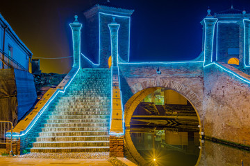 ancient bridge at night lit by Christmas lights