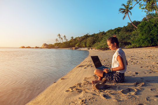 Woman with a laptop on the beach