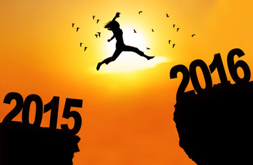 Woman jump through gap with numbers 2015 and 2016