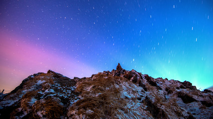 Star trails over the winter mountains landscape.
