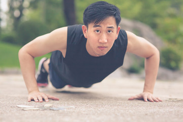 Young Asian Man doing push ups outdoor