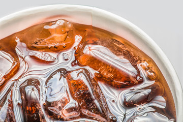 Cola in glass with ice on white background, Close up