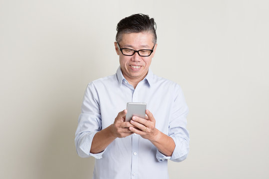 Mature Asian Man Using Smartphone