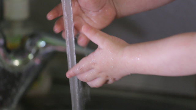 Child's hand playing with drinking water, close-up