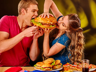 Woman and man feed each other fast food. Concept.