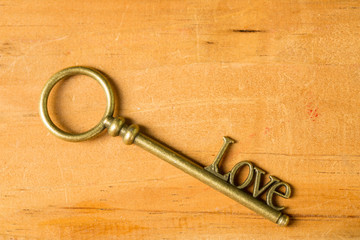 Love and Romance Vintage concept with engagement ring, love shape key placing on wooden table