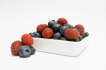 mix of blueberries and raspberries isolated on a white background