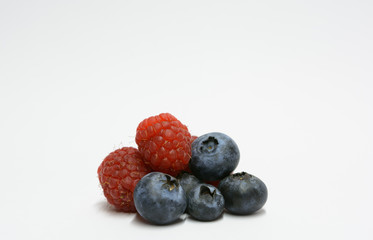 mix of blueberries and raspberries isolated on a white background