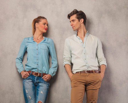couple looking at each other with hands in pockets