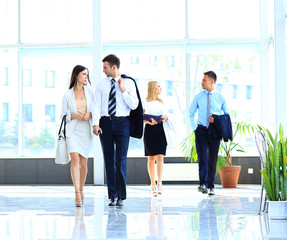 businesspeople group walking at modern bright office interior