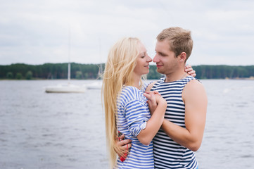 Fototapeta na wymiar Portrait of a romantic couple in a striped T-shirt hugging and smiling, lifestyle, love, romance, relationships