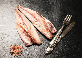 raw fresh mackerel fillet with pink himalayan salt over slate