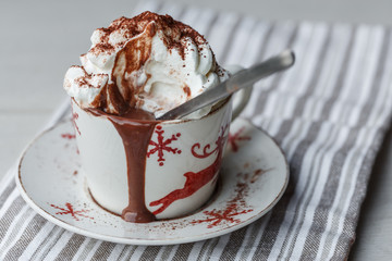 Une tasse de chocolat chaud avec de la crème fouettée et de la poudre de cacao