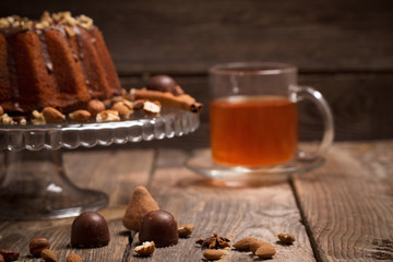 cake, candy, nuts and cup  on old wooden background