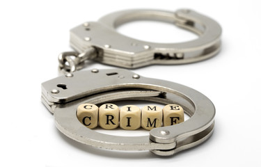 Handcuffs with word crime on wooden cubes