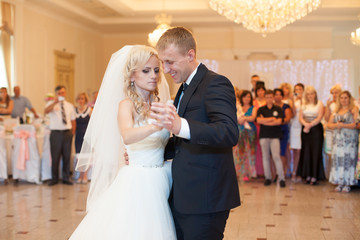 happy elegant married couple performing first dance in a restaur