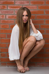 woman sitting against the brick wall