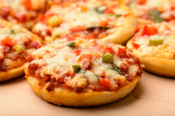 Mini pizzas on wooden board.