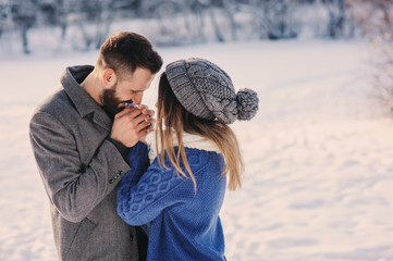 happy loving couple walking in snowy winter forest, spending christmas vacation together. Outdoor seasonal activities. Lifestyle capture.